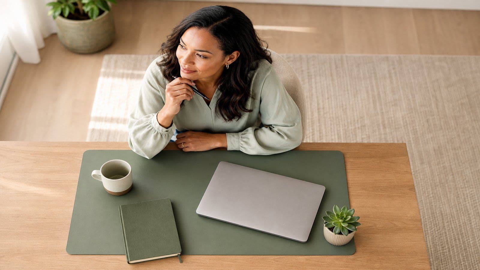 A small-business owner reviews her monthly numbers at a tidy home-office desk